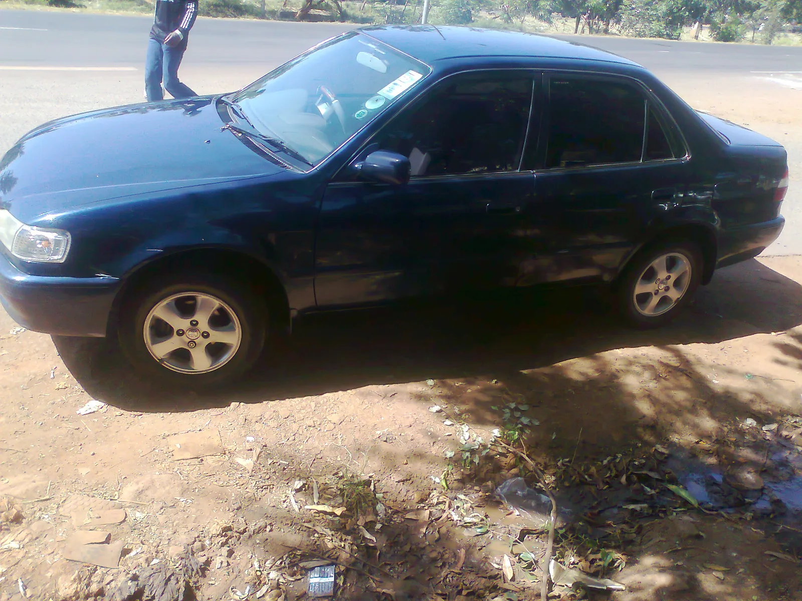 Dark green Toyota Corolla parked on a verge