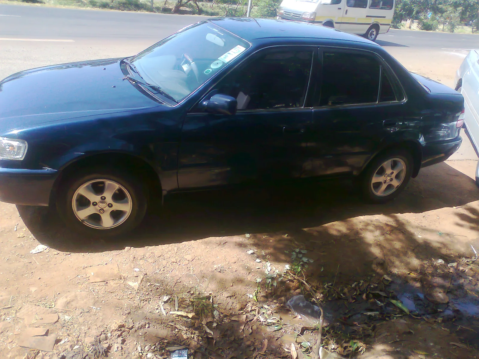 Dark green Toyota Corolla saloon
